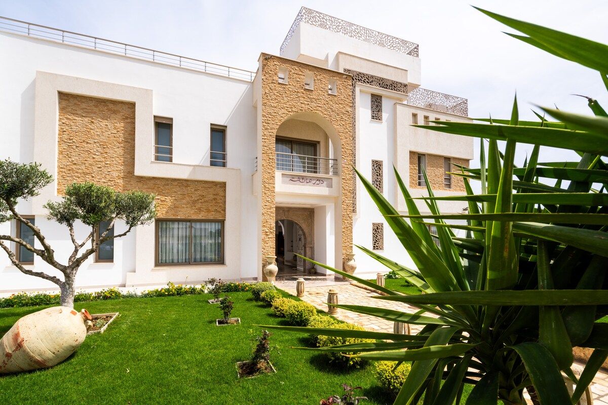 Allée bordée de palmiers menant à la villa