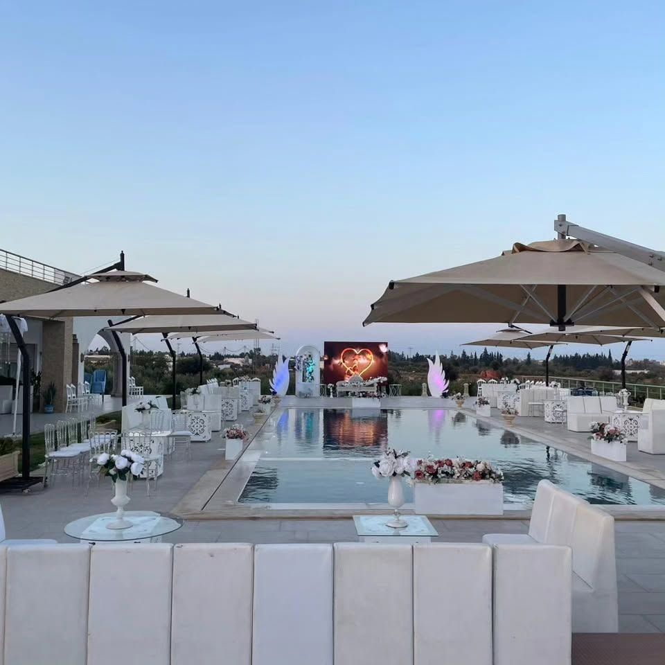 Réception de mariage organisée au bord de la piscine de Dar Aïcha, décoration blanche et lumineuse au crépuscule