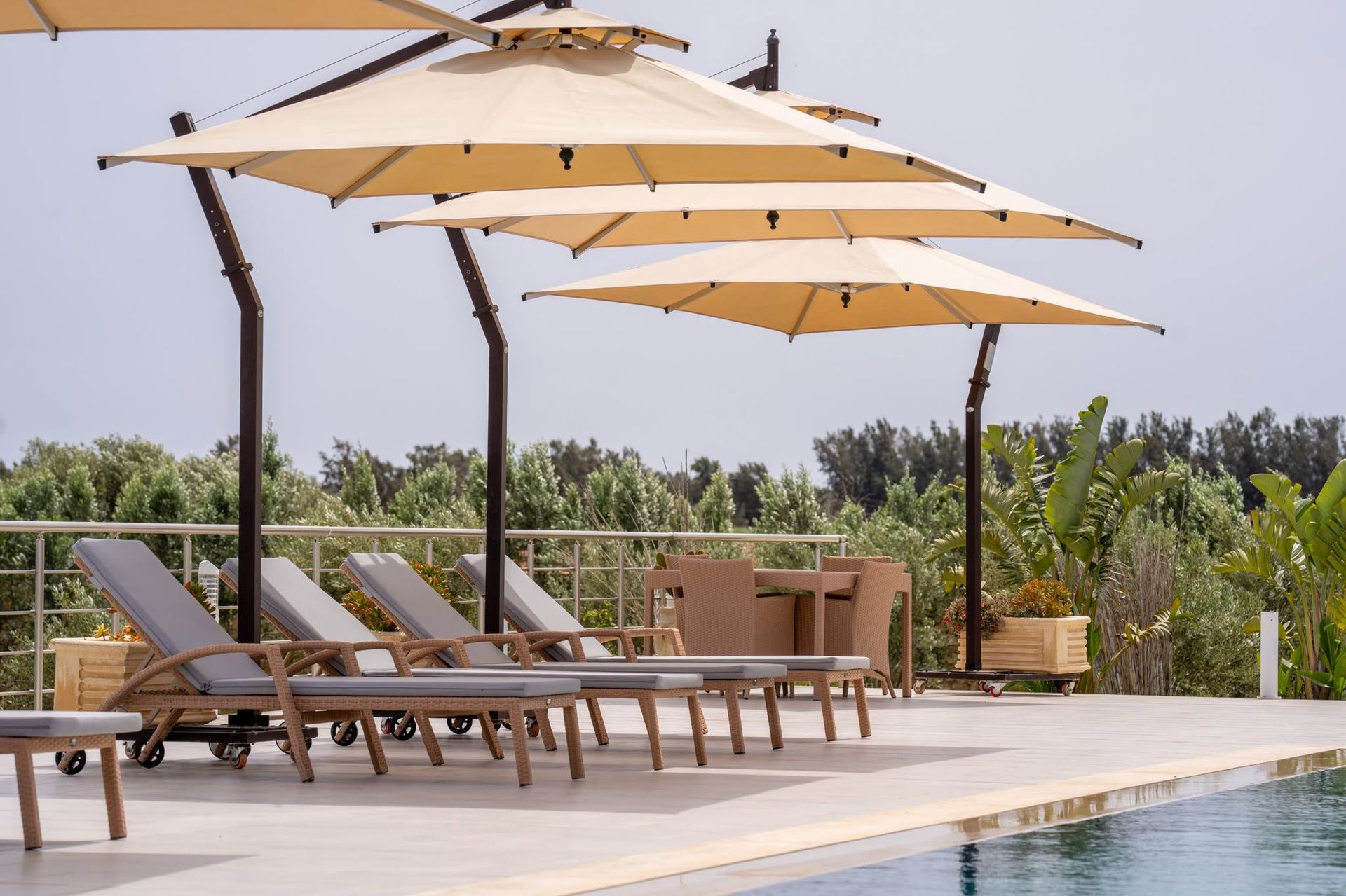 Terrasse piscine aménagée avec parasols suspendus à la villa Dar Aïcha