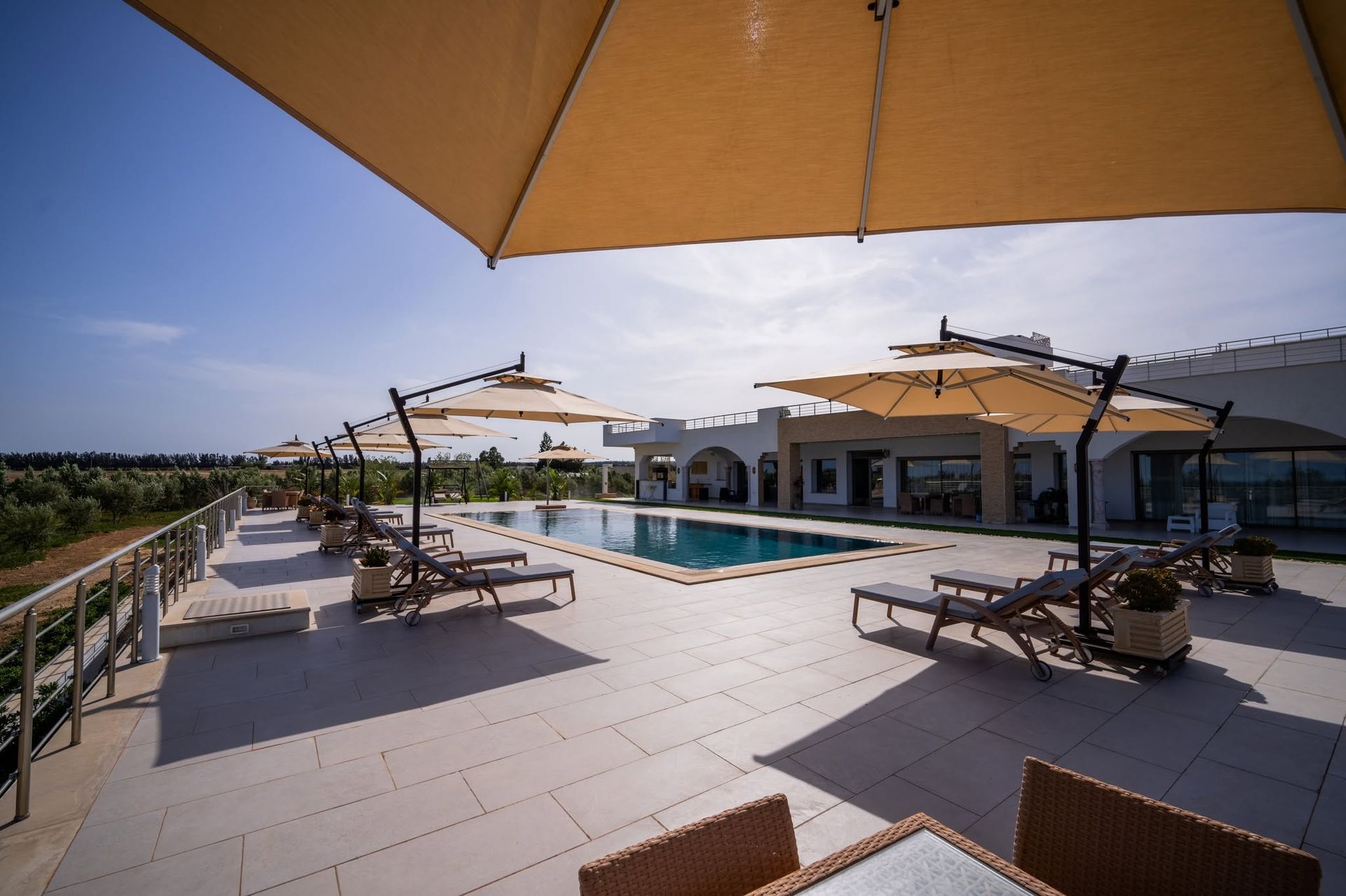 Transats et parasols en bord de piscine à la villa Dar Aïcha