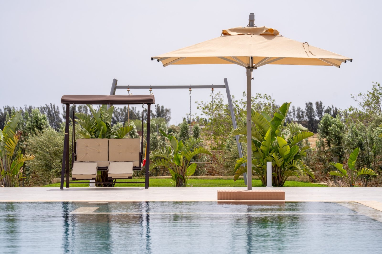 Balancelle et portique pour enfants près de la piscine à débordement