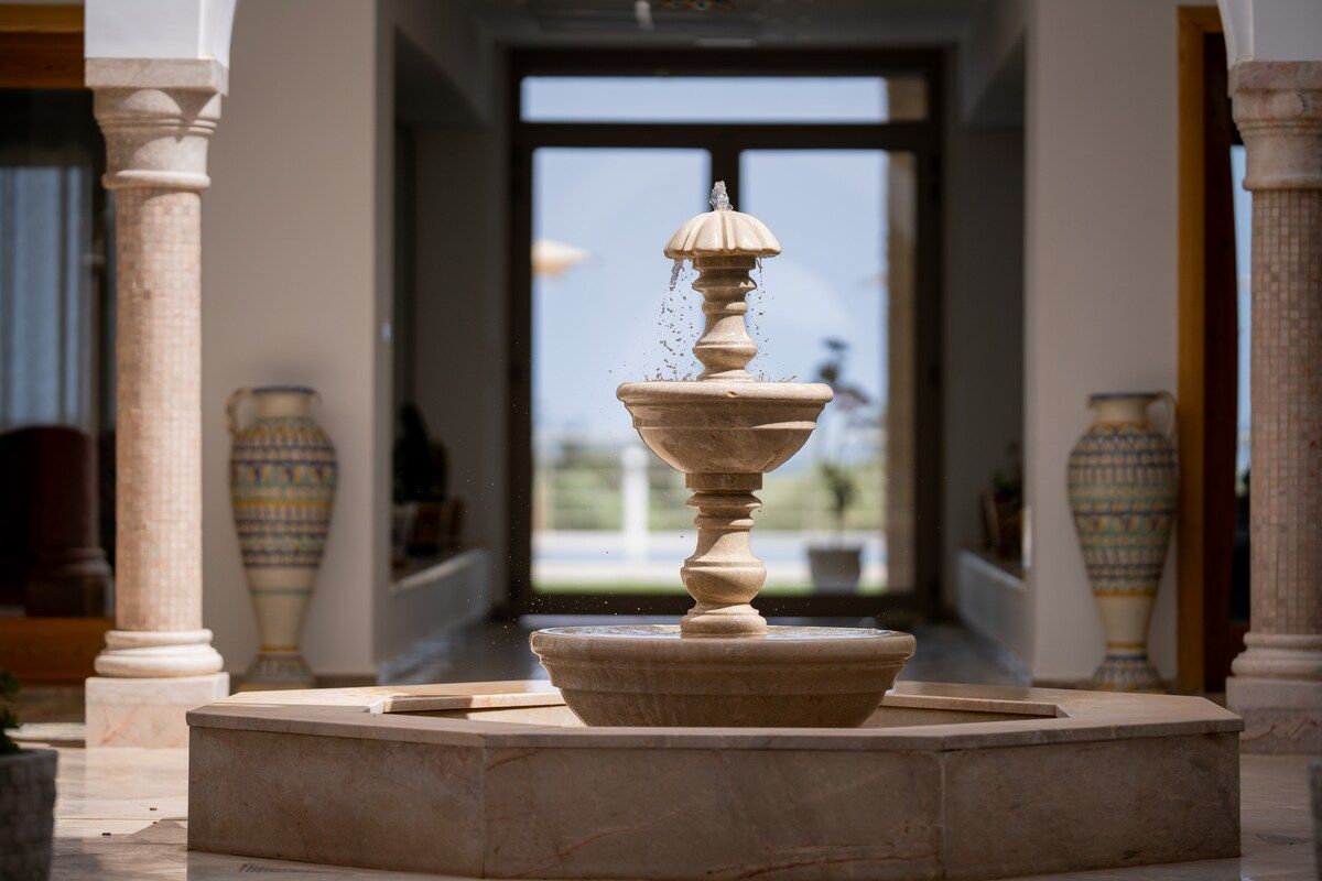 Patio central de la villa Dar Aïcha avec fontaine en zellige, cadre pour retraites et séminaires
