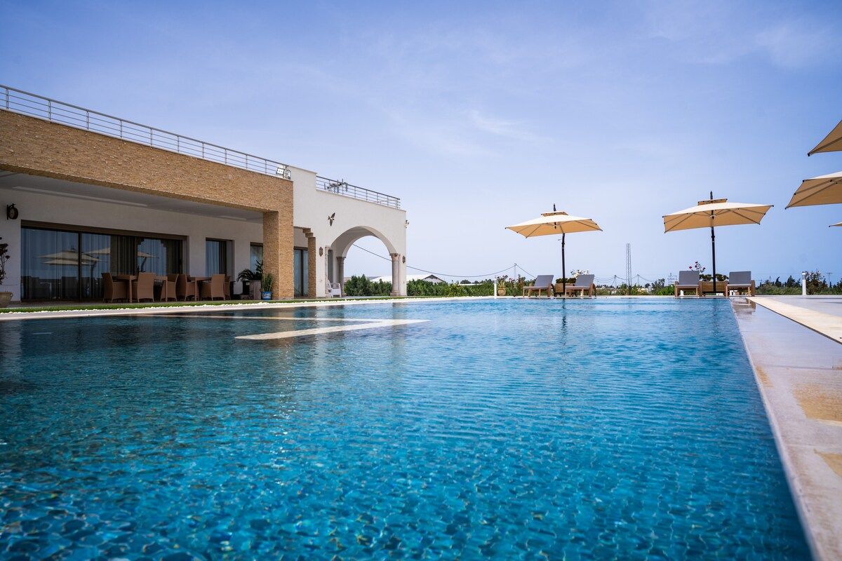 Terrasse et piscine de Dar Aïcha, ambiance calme en basse saison, transats disposés au bord de l'eau