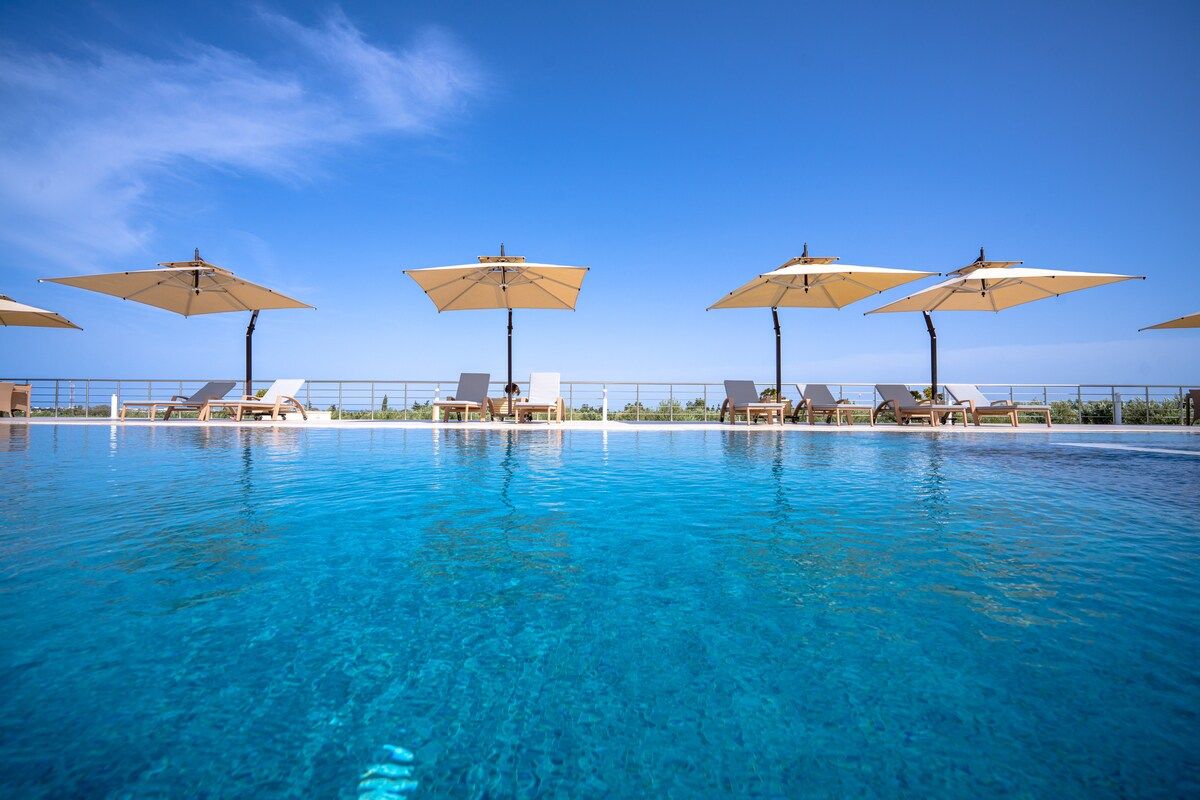 Espace piscine aménagé pour un événement, transats et parasols beiges